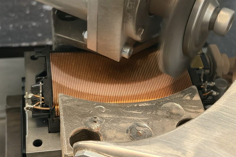 Bürstmaschine im Einsatz: Die Kupferwicklung eines Modellbahn-Fahrreglers wird gebürstet, damit sie – ähnlich einem Potentiometer – abgreifbar ist